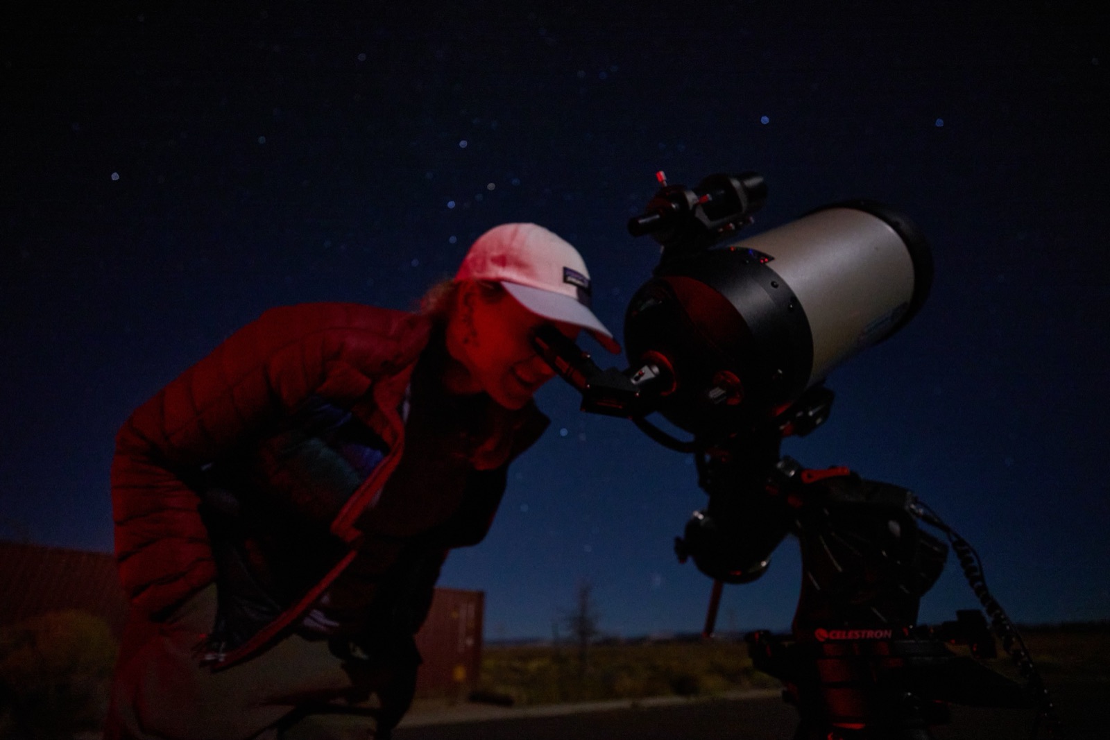 A guest looking through a Celestron telescope eyepiece at a stargazing event